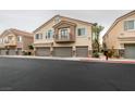 Two-story townhouse featuring private balconies, and two-car garages with stone accents at 8675 Traveling Breeze Ave # 101, Las Vegas, NV 89178