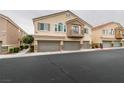 Two-story townhouse featuring private balconies, and two-car garages with stone accents at 8675 Traveling Breeze Ave # 101, Las Vegas, NV 89178