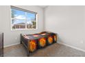 Cozy bedroom featuring a metal frame bed, large window, and neutral carpet at 8929 Cassia Winds St, Las Vegas, NV 89166