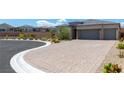 Paver driveway leading to a well-manicured home with desert landscaping at 8929 Cassia Winds St, Las Vegas, NV 89166