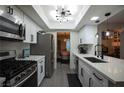 Bright kitchen with stainless steel appliances, white cabinetry, and modern lighting at 9013 Cypress Point Way, Las Vegas, NV 89117