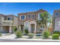 Charming two-story home featuring desert landscaping, a private entry porch with chairs, and an attached one car garage at 9065 Adorable Ave, Las Vegas, NV 89149