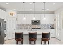 Bright kitchen featuring white cabinetry, a center island with bar seating, and stainless steel appliances at 10127 Knotty Skye Ave, Las Vegas, NV 89166