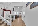 Bright foyer featuring a staircase, wood-look tile flooring, and decorative wall art at 10415 Sadie Blake Ave, Las Vegas, NV 89166