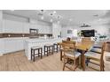 Open-concept kitchen with white cabinets, stainless steel appliances, and a breakfast bar with seating at 10415 Sadie Blake Ave, Las Vegas, NV 89166