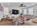 Cozy living room with modern furniture, large TV, ceiling fan, and plenty of natural light at 10415 Sadie Blake Ave, Las Vegas, NV 89166