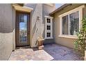 Inviting front entrance with a decorative glass door and beautiful stone accents at 10520 Maystar Ln, Las Vegas, NV 89135