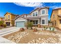 Charming two-story home with a two-car garage and desert landscaping with a beautiful, natural rock feature at 140 Rolling Cove Ave, Henderson, NV 89011