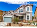 Charming two-story home with a two-car garage and desert landscaping with a beautiful, natural rock feature at 140 Rolling Cove Ave, Henderson, NV 89011
