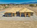 New construction home with a bright blue sky and wooden framing with mountains in the background at 1550 W Jornada St, Pahrump, NV 89048
