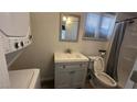 Bright bathroom featuring shower, toilet, vanity and sink, and stacked washer/dryer at 1844 Yale St, North Las Vegas, NV 89030