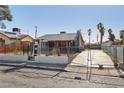 A full front exterior shot of this house with a fenced yard and a gated driveway at 1844 Yale St, North Las Vegas, NV 89030