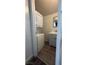 Compact laundry area features a stacked washer/dryer unit and a modern sink and vanity at 1844 Yale St, North Las Vegas, NV 89030