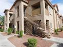 The exterior of a two-story tan condo building features a stairwell leading to the second floor at 2110 Los Feliz St # 1083, Las Vegas, NV 89156