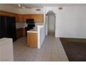A kitchen is featured with wood cabinets and black appliances including a refrigerator, stove and microwave at 2110 Los Feliz St # 1083, Las Vegas, NV 89156