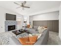 A modern living room with a decorative fireplace, neutral-toned walls and floors, and a comfortable gray sofa at 2337 Sierra Sunrise St, Las Vegas, NV 89156