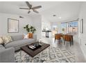 Bright living room with modern furniture, a ceiling fan, and a dining area flooded with natural light at 2337 Sierra Sunrise St, Las Vegas, NV 89156
