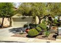 Charming home featuring mature trees, manicured bushes, and a spacious two-car garage at 3048 Scalise Ct, Las Vegas, NV 89141