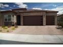 Charming single-story home featuring a brick-accented facade and a spacious two-car garage at 3395 Sleeping Hills Ave, Henderson, NV 89044