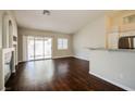 Open-concept living room with dark wood floors and sliding door to the outside at 3416 Steppe St, North Las Vegas, NV 89032