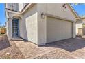 Close up of the 2-car garage and front door with brick paved driveway at 4145 Nopal Serrano Ave, Las Vegas, NV 89141