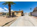 This home offers desert landscaping with mature palm tree, long driveway and covered front porch at 513 Berry Cir, Las Vegas, NV 89107