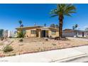 Charming single-story home featuring desert landscaping, a front yard palm tree, and a covered front porch at 513 Berry Cir, Las Vegas, NV 89107