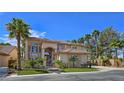 Elegant two-story home featuring a tiled roof, desert landscaping, and a secure gated entrance at 5445 Pendini Point Ct, Las Vegas, NV 89141