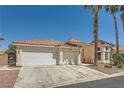 Inviting single-story home showcasing a three-car garage, desert landscaping, and tile roof at 5638 Wild Olive St, Las Vegas, NV 89118