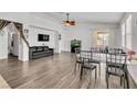 Open-concept living room with hardwood floors, ceiling fan, TV, and access to outdoor patio at 6829 Painted Morning Ave, Las Vegas, NV 89142
