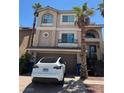 Charming two-story home features a stucco exterior, arched windows, and a well-manicured front yard at 6877 Philharmonic Ave, Las Vegas, NV 89139