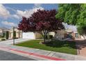 Lovely home with well-maintained lawn and mature tree in front at 7697 Morning Lake Dr, Las Vegas, NV 89131