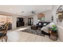 Bright living room featuring a ceiling fan, fireplace, tile flooring, and sliding door access to the yard at 7697 Morning Lake Dr, Las Vegas, NV 89131