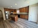 This kitchen features wood cabinets, stainless steel appliances, granite counters and an island, perfect for cooking at 7929 Valladolid Ave, Las Vegas, NV 89178
