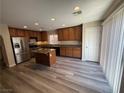 Bright kitchen featuring wood cabinetry, stainless steel appliances, granite countertops, island, and ample natural light at 7929 Valladolid Ave, Las Vegas, NV 89178