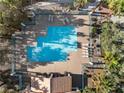Aerial view of a community pool featuring lounge chairs and lush landscaping all around at 7984 Laurena Ave, Las Vegas, NV 89147