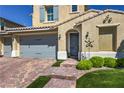 Charming home featuring a three-car garage, arched entryway, and manicured landscaping at 8126 Majestic Bighorn St, Las Vegas, NV 89166