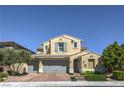 Inviting two-story home featuring a three-car garage, manicured lawn, and charming architectural details at 8126 Majestic Bighorn St, Las Vegas, NV 89166