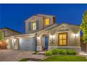 Two-story home featuring a three-car garage and illuminated exterior, enhancing its curb appeal at 8126 Majestic Bighorn St, Las Vegas, NV 89166