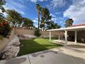 Spacious backyard featuring lush lawn, rock garden, and covered patio, perfect for outdoor relaxation at 8316 Vibrant Dr, Las Vegas, NV 89117