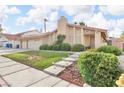 Inviting home exterior featuring a lush lawn, stone walkway, and mature landscaping at 8316 Vibrant Dr, Las Vegas, NV 89117