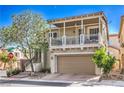 Charming two-story home boasts a covered balcony, tan siding, and a well-manicured front yard at 9822 Opal Bridge Ct, Las Vegas, NV 89178