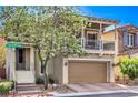 Charming two-story home boasts a covered balcony, tan siding, and a well-manicured front yard at 9822 Opal Bridge Ct, Las Vegas, NV 89178