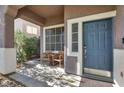 Inviting covered front porch with seating and a blue front door at 10046 Floragold Ct, Las Vegas, NV 89147