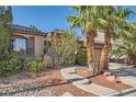 Charming single-story home showcasing a well-kept lawn, desert landscaping, and an attached two-car garage at 10310 Songsparrow Ct, Las Vegas, NV 89135