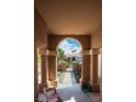 Covered entry way features beautiful archway leading to the street and a desert-landscaped front yard at 10720 Sky Meadows Ave, Las Vegas, NV 89134