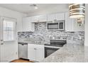 Modern kitchen featuring stainless steel appliances, granite countertops, stylish tile backsplash, and a stainless steel faucet at 1121 W Monroe Ave, Las Vegas, NV 89106