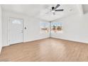 A bright living room filled with natural light, featuring wood-look flooring, a modern ceiling fan, and two large windows at 1121 W Monroe Ave, Las Vegas, NV 89106