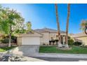 Charming single-story home featuring a manicured lawn, mature trees, and a well-maintained driveway at 1506 Camino Summit Ave, Henderson, NV 89012