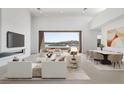 Bright living room featuring modern furnishings, a fireplace, and a stunning lake view through large sliding glass doors at 1596 Pleasant Bay Ct, Henderson, NV 89011